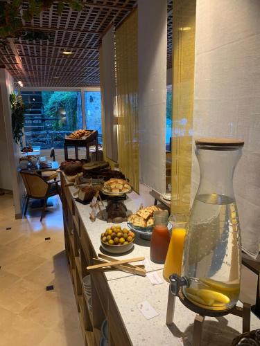 Una línea de buffet con comida y un jarrón de jugo. en Le Moulin Des Ruats, en Avallon