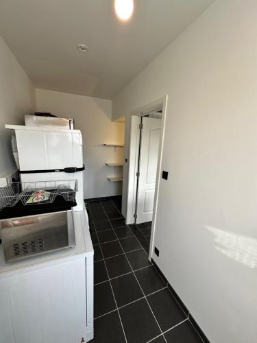 a kitchen with a white refrigerator and a tile floor at De Karlapper in Lokeren