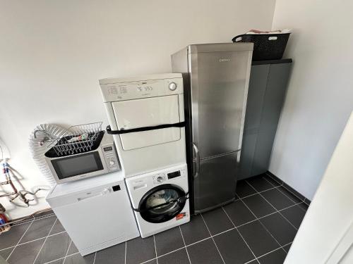 a kitchen with a washing machine and a refrigerator at De Karlapper in Lokeren