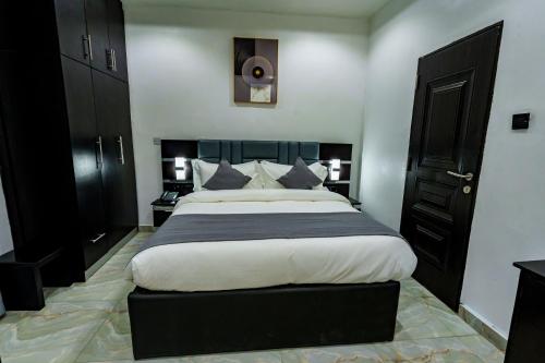 a bedroom with a large bed with a black headboard at Roston Hotels in Port Harcourt