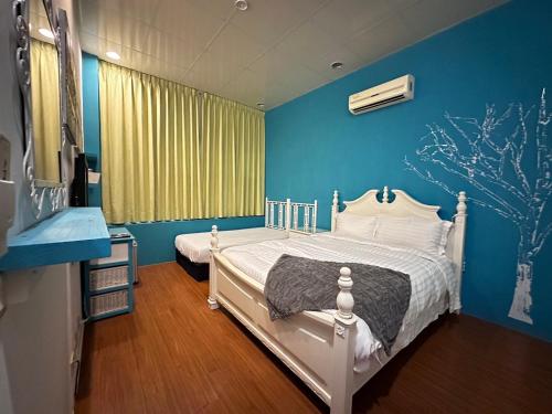una camera con un letto bianco e una parete blu di 彤林溫泉民宿 a Jiaoxi