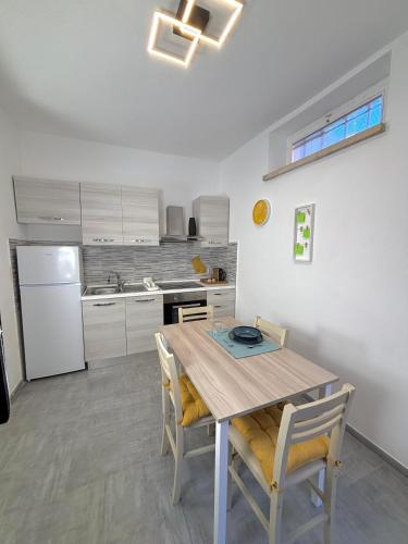 a kitchen with a wooden table and two chairs at Il Vicolo, 200m dal centro storico, 25 min da Roma in Monterotondo