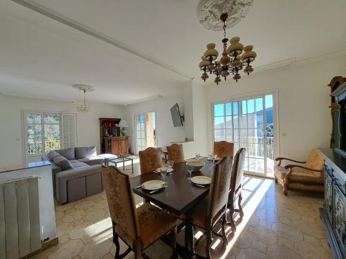 une salle à manger et un salon avec une table et des chaises dans l'établissement Location haut de villa privatif - vue mer, à Santa-Maria-di-Lota