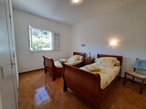 une chambre avec deux lits et une fenêtre dans l'établissement Location haut de villa privatif - vue mer, à Santa-Maria-di-Lota