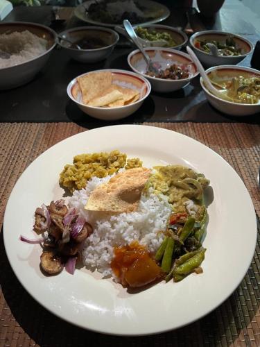 a plate of food on a table with rice at Villa Sun Rising in Talpe