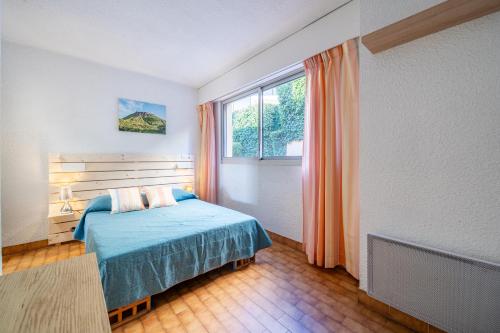 a bedroom with a bed and a window at Résidence "Le Golfe Bleu" in Roquebrune-Cap-Martin