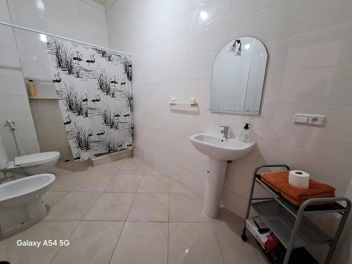 a white bathroom with a sink and a mirror at Spartel House 05 in Tangier