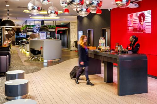 a woman walking past a counter in a store at ibis London Blackfriars in London