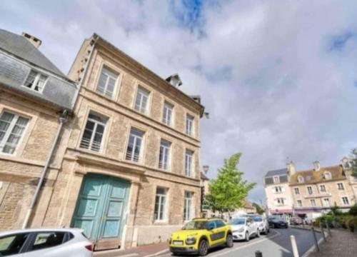 une voiture jaune garée devant un bâtiment dans l'établissement Basilique XI, à Douvres-la-Délivrande