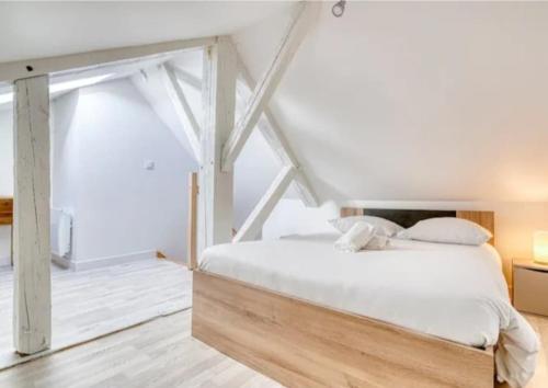 une chambre avec un grand lit avec des draps blancs dans l'établissement Basilique XI, à Douvres-la-Délivrande