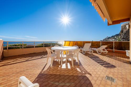 a patio with a table and chairs on a balcony at Résidence "Le Golfe Bleu" in Roquebrune-Cap-Martin