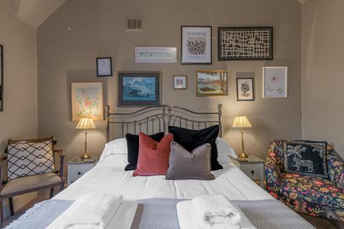 a bedroom with a bed with pillows and a chair at 1869 - Room Only Boutique Townhouse in Ambleside