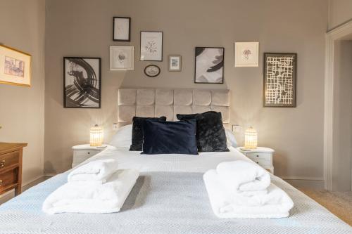 a bedroom with a large bed with two white chairs at 1869 - Room Only Boutique Townhouse in Ambleside