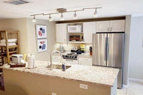 a kitchen with a stainless steel refrigerator and white cabinets at 14th 99 Walk Score 3 mins to Metro rail in Washington, D.C.