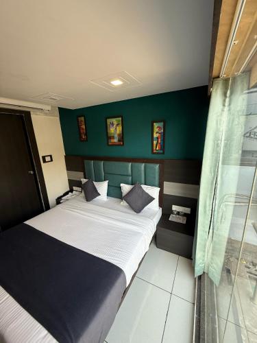 a bedroom with a bed and a green wall at Hotel Sunview in Ahmedabad