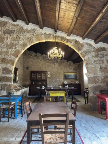 a dining room with tables and chairs in a stone wall at Feudo Nobile in Gela