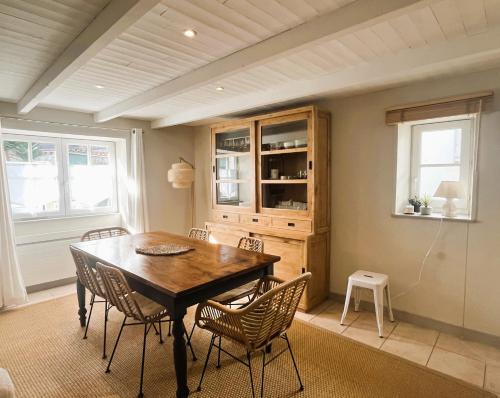 une salle à manger avec une table et des chaises en bois dans l'établissement ORIANE maison de charme proche Plage, à Sainte-Marie de Ré