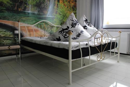 a white bed with black and white pillows on it at Gästehaus Mama in Rust