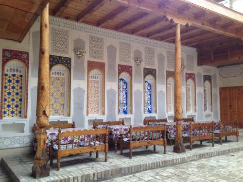 a row of benches in a room with stained glass windows at Sukhrob Barzu Hotel in Bukhara