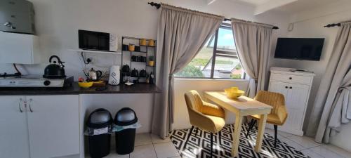 a kitchen with a table and chairs and a window at South Of Africa in Agulhas