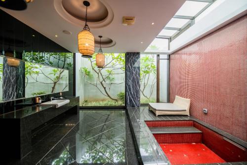 a bathroom with red tile and a red wall with trees at Ease Motel in Caotun