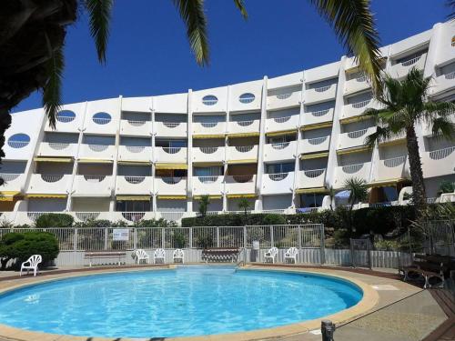 un hôtel avec une piscine devant un immeuble dans l'établissement Appartement 4 Pièces, Vue Mer, Piscine et Parking privé, à La Grande Motte