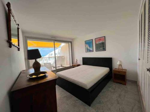 une chambre avec un lit, un bureau et une fenêtre dans l'établissement Appartement 4 Pièces, Vue Mer, Piscine et Parking privé, à La Grande Motte