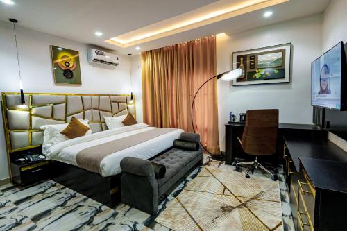 哈科特港Roston Hotels的一间卧室，配有一张床、一张书桌和一台电视