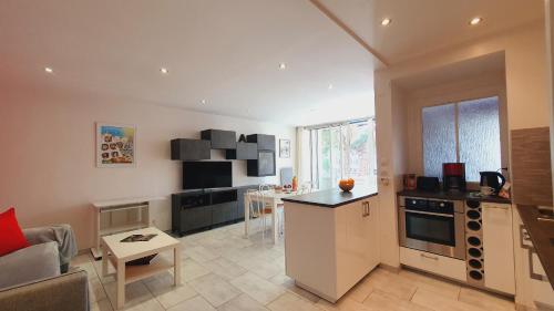 Il dispose d'une cuisine et d'un salon avec une table et un canapé. dans l'établissement Charmant T2 Centre-ville Parking Clim Wifi - ROSSIconciergerie - Linge inclus, à La Grande Motte