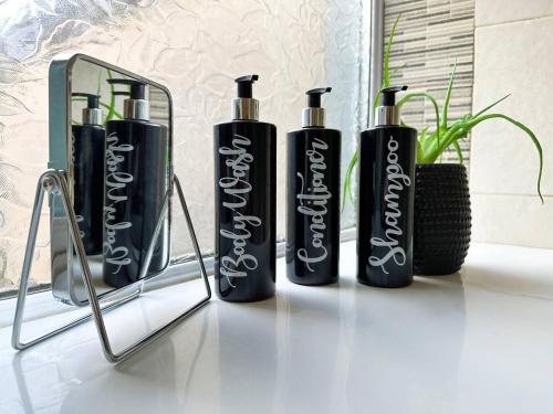 a group of four black bottles sitting on a counter at On Trend 3 Bedroom Home In Maerdy Near Attractions in Maerdy