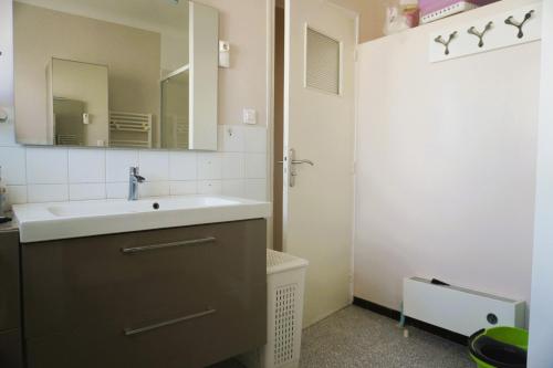 une salle de bain avec un lavabo et un miroir dans l'établissement Le Flamant Rose 5 minutes plage Clim 5 Pers, à Fitou