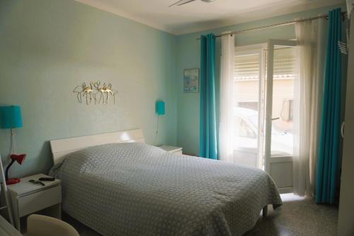 - une chambre dotée d'un lit avec des murs bleus et des rideaux bleus dans l'établissement Le Flamant Rose 5 minutes plage Clim 5 Pers, à Fitou