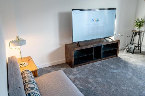 a living room with a large flat screen tv at Manchester Cityside Deluxe Stay - 3 Bedroom House Great for Family with Free Parking & Garden in Manchester