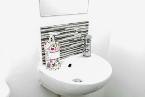 a white bathroom with a sink and a toilet at Manchester Cityside Deluxe Stay - 3 Bedroom House Great for Family with Free Parking & Garden in Manchester