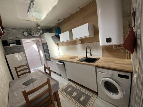 une cuisine avec un lave-linge, une table et des chaises dans l'établissement Ninette, à Fort-Mahon-Plage