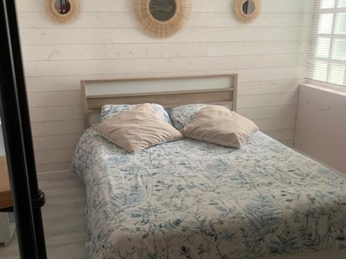 une chambre avec un lit avec deux oreillers dessus dans l'établissement Ninette, à Fort-Mahon-Plage