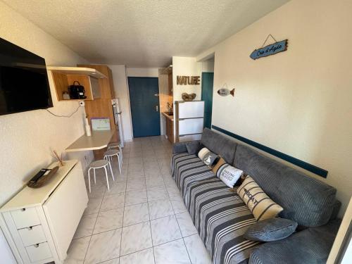 un salon avec un canapé et une table dans l'établissement Charmant T2 avec piscine et parking privatif au Cap d'Agde, idéal pour 4 personnes - FR-1-749-72, au Cap d'Agde