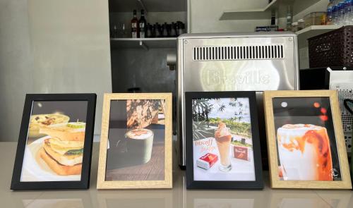 a group of pictures in frames on a table at A & L Resort - Sea & Mountain View in Looc