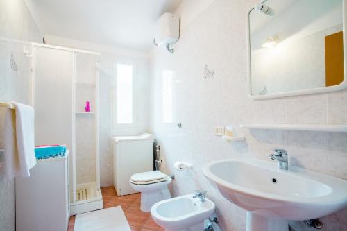 une salle de bain blanche avec un lavabo et des toilettes dans l'établissement Sun House 4 Villasimius City Center AirConditioned, à Villasimius