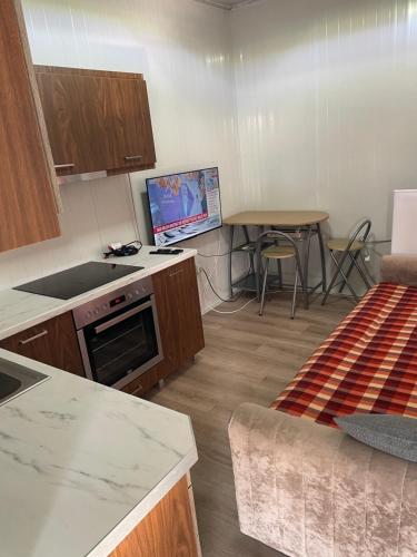 a kitchen with a table and a tv in a room at Mahane in Tirana
