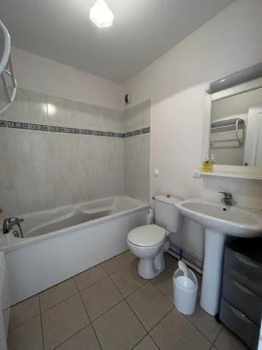 une salle de bain avec une baignoire, des toilettes et un lavabo dans l'établissement Les Astéries 24 - Duplex, à Quend-Plage
