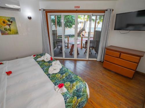a bedroom with a bed with a television and a living room at Maya Beach Hotel in Maya Beach