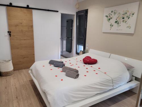 - une chambre avec un lit blanc et des coeurs rouges dans l'établissement Magnifique Villa piscine privée jacuzzi, à Saint-Féliu-dʼAvall