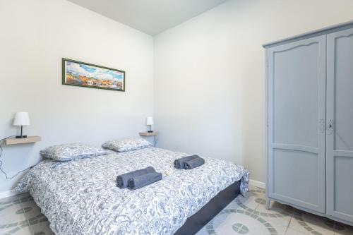 une chambre avec un lit avec deux chaussures dessus dans l'établissement Le Patio Bleu - Les CAMOINS, à Marseille