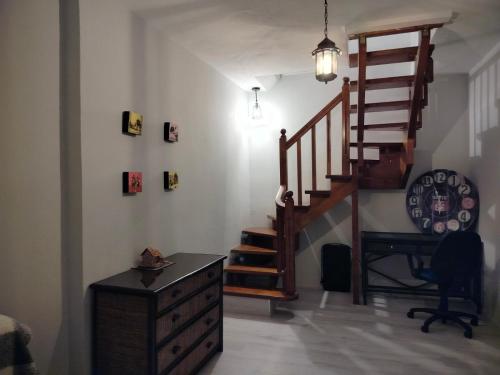 a living room with a wooden staircase and a desk at Garden Home in Vari