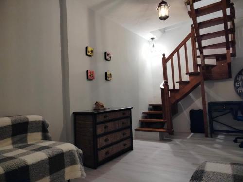 a room with a staircase and a dresser and a chair at Garden Home in Vari