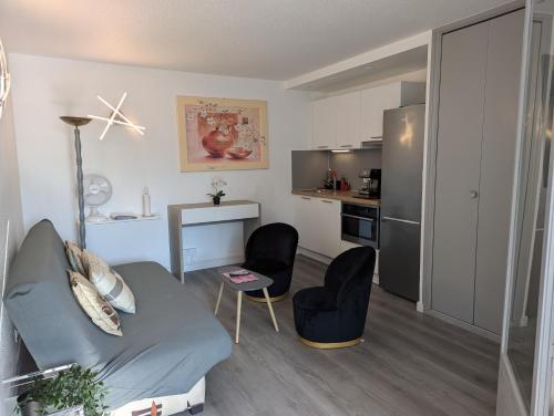 un salon avec un canapé et une cuisine dans l'établissement Sol-y-Days Sloop appartement 2 chambres avec parking, au Grau-du-Roi
