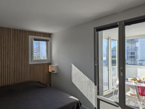 une chambre avec un lit et une porte coulissante en verre dans l'établissement Sol-y-Days Sloop appartement 2 chambres avec parking, au Grau-du-Roi