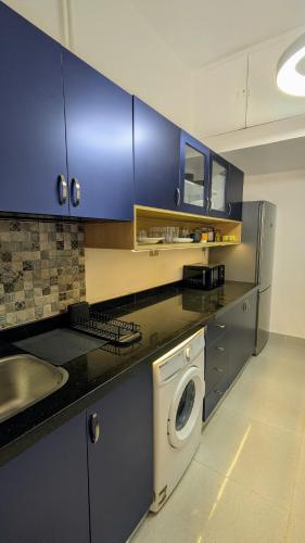 a kitchen with a washing machine and a sink at Mesaha I Madina Apt I 2min to Nile in Cairo