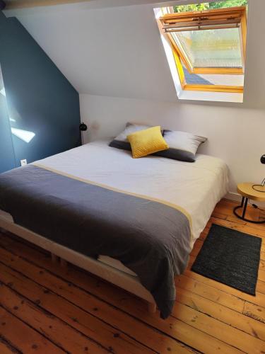 une chambre avec un grand lit avec une fenêtre dans l'établissement Le Saut Mur, à Saumur